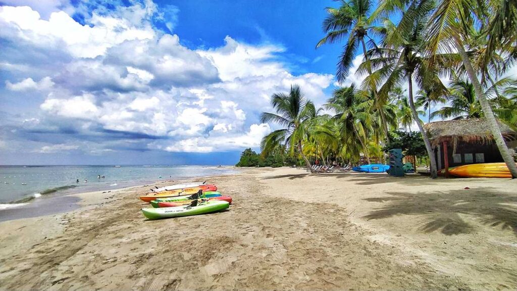 The beach resort of Club Med with palm trees, kayaks, and a beach club